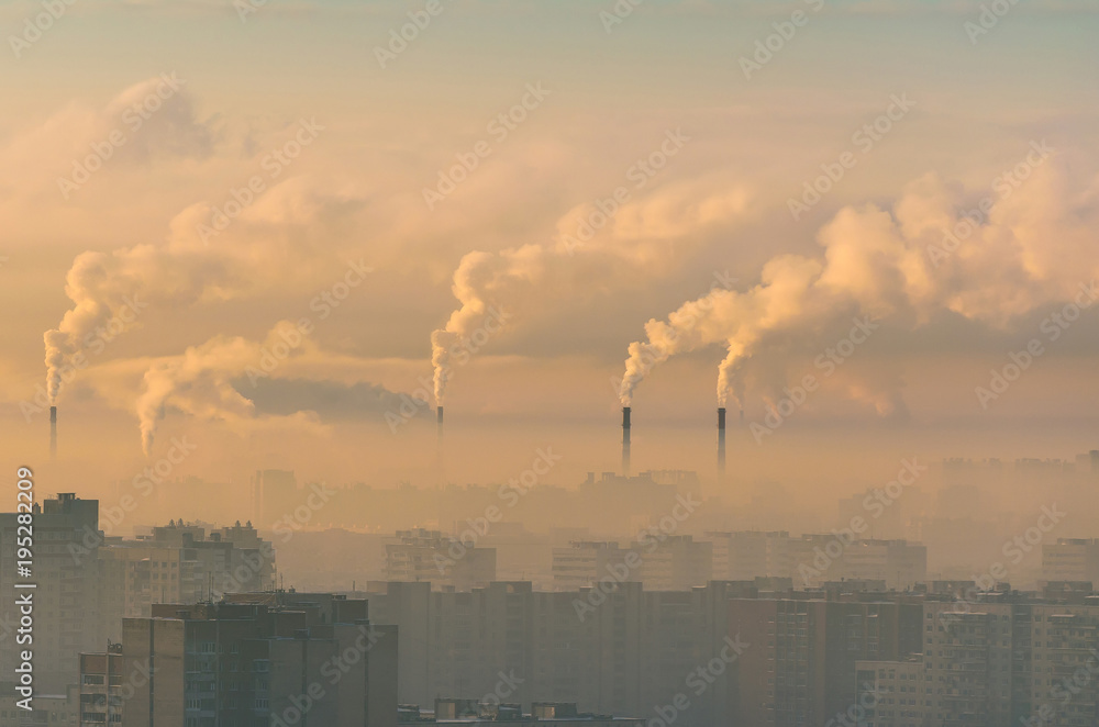 Urban landscape smoked polluted atmosphere from emissions of plants and factories, view of pipes with smoke and residential apartment buildings.