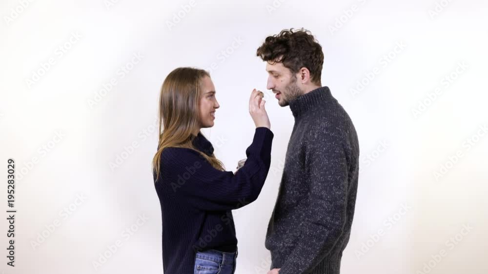 A couple eating a cookie from a jar A couple eating a cookie from a jar