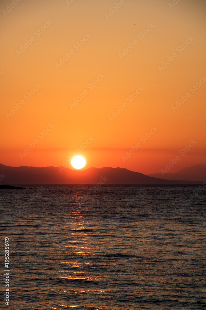 Traumhafter Sonnenuntergang am Mittelmeer hinter einer bergigen Insel