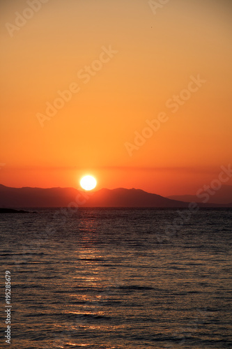 Traumhafter Sonnenuntergang am Mittelmeer hinter einer bergigen Insel