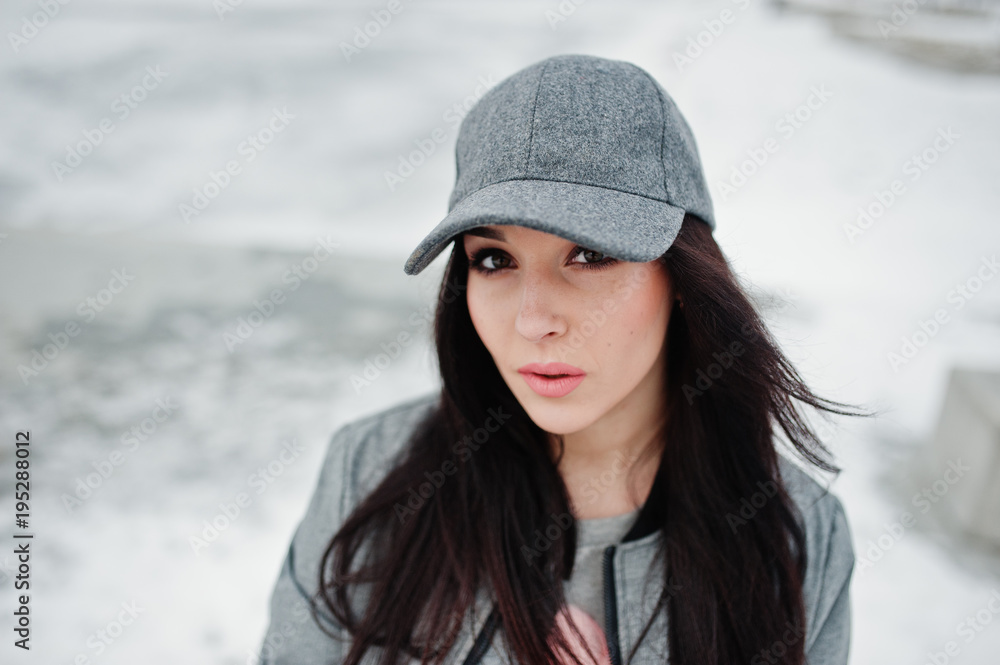 Stylish brunette girl in gray cap, casual street style on winter day. Stylish brunette girl in gray cap, casual street style on winter day.