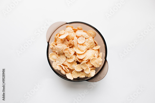 delicious crispy cornflakes in bowl on white background, healthy breakfast