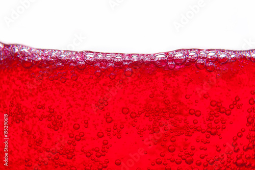 red soda water splashing with bubbles close up and Dew Point on glass