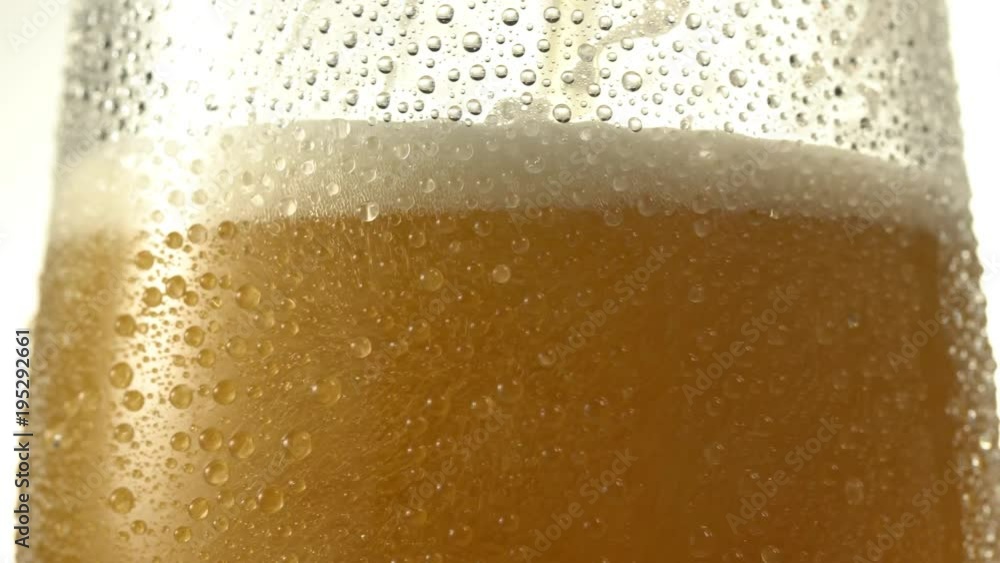 Stream of beer pours into a rotating beer glass. Close up 4K video. Macro shooting. Stream of beer pours into a rotating beer glass. Close up 4K video. Macro shooting.