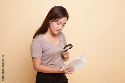 Asian woman with a book and magnifying glass.