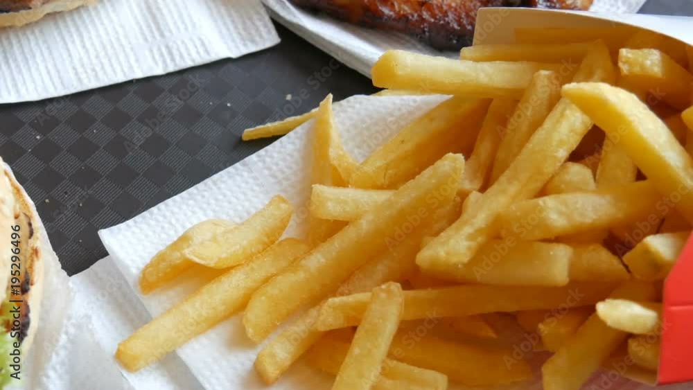On tray is fast food. Not healthy food on the table burgers, french fries and fried chicken wings On tray is fast food. Not healthy food on the table burgers, french fries and fried chicken wings