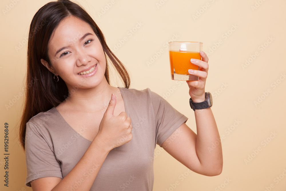 Young Asian woman thumbs up drink orange juice. Young Asian woman thumbs up drink orange juice.
