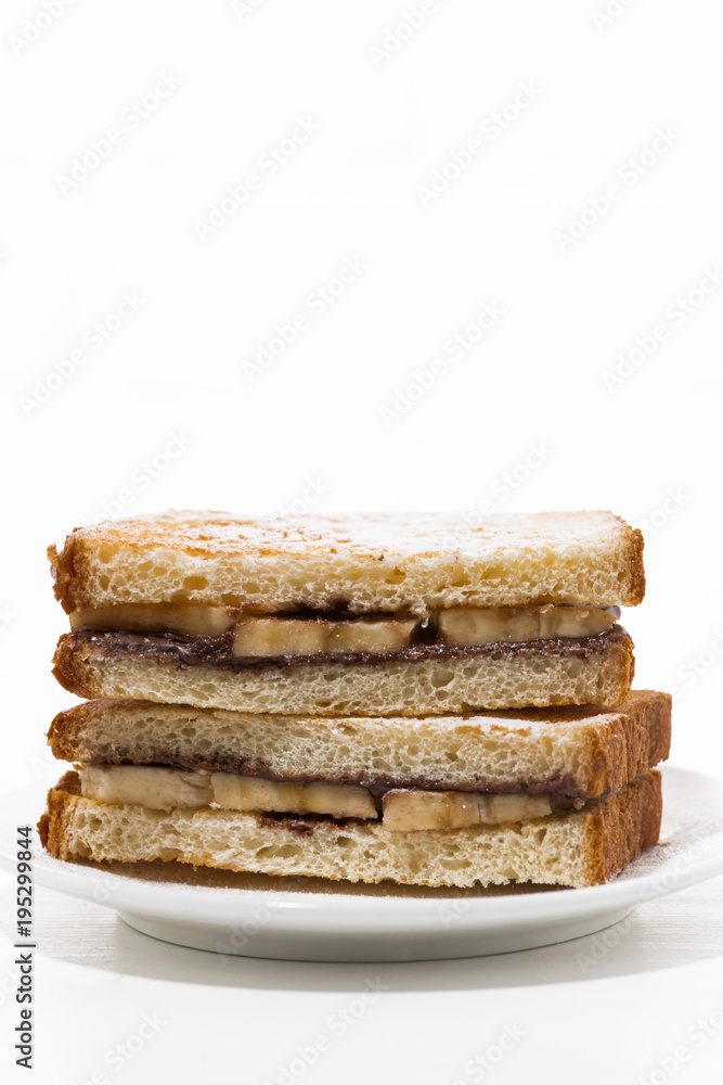sweet sandwich with chocolate paste and banana on white plate, vertical sweet sandwich with chocolate paste and banana on white plate, vertical