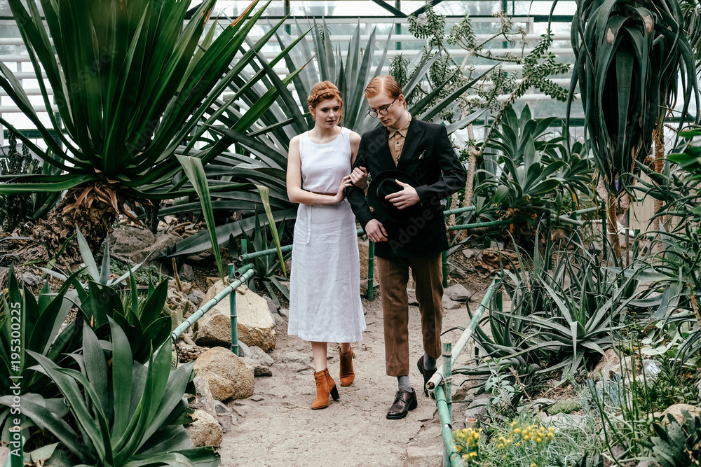 romantic bride and groom walking in greenhouse
