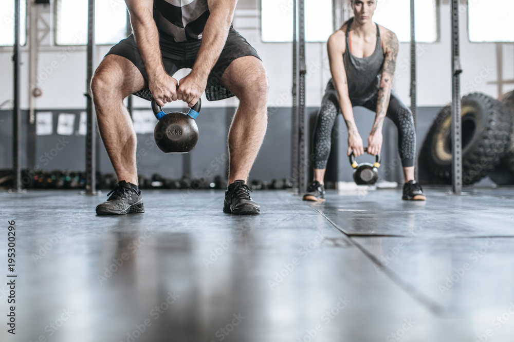 Fototapeta premium Sportsmen and Sportswomen Lifting Weights at Gym