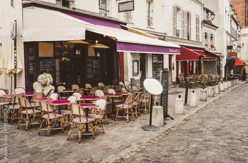 Cozy street with tables of cafe in quarter Montmartre in Paris, France
