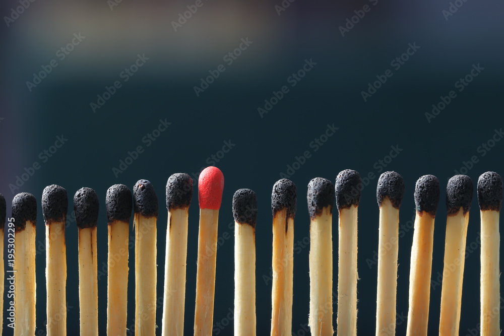 Match standing out from others on dark background. Difference and uniqueness concept Match standing out from others on dark background. Difference and uniqueness concept