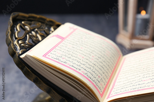 Open holy book of Muslims on stand, closeup