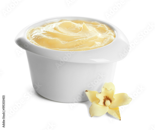 Leinwand Poster Tasty vanilla pudding in ramekin and flower on white background