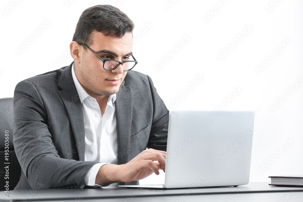 Young man in office wear working with laptop at table Young man in office wear working with laptop at table