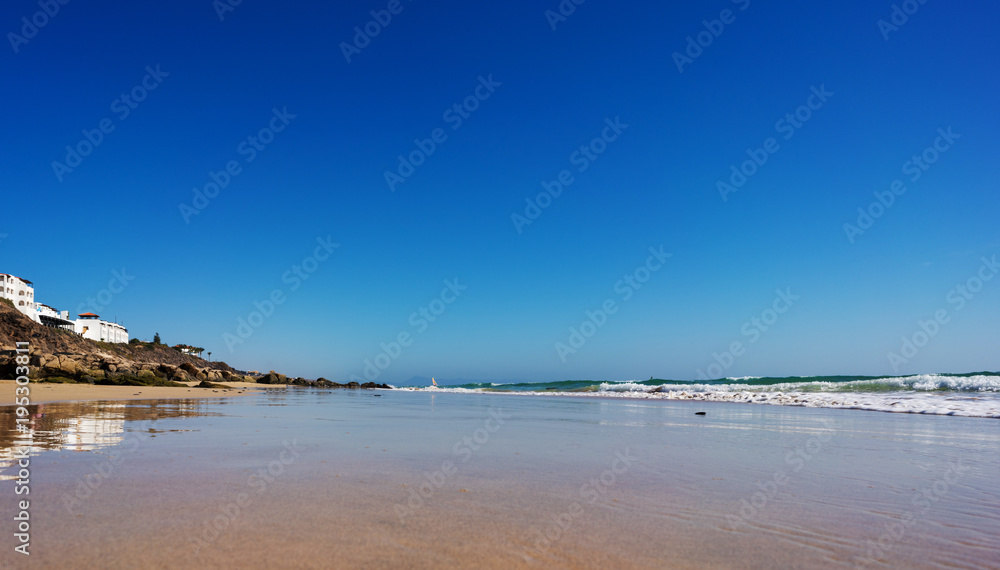 Calm sea and surf on a sandy beach. summer sea in Sunny weather with blue sky. Beautiful sandy beach and transparent waves