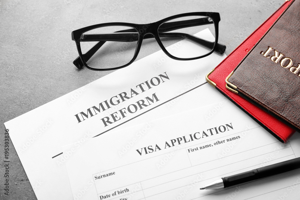 Passports, glasses and visa application form on table. Immigration reform Passports, glasses and visa application form on table. Immigration reform