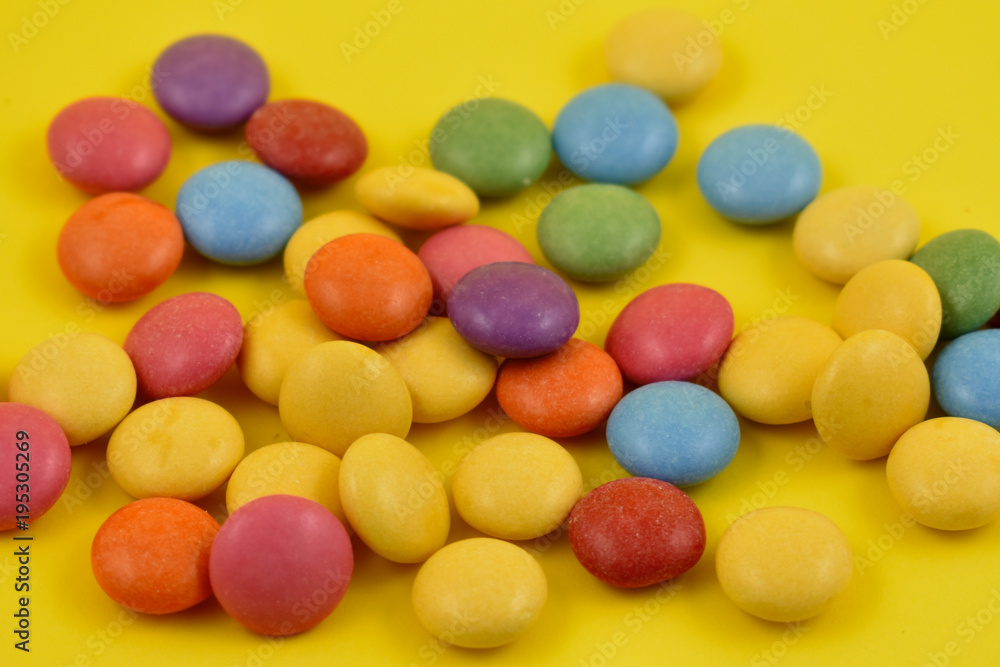 Colorful chocolate lentils candy close-up stock photo images. Multicolored round candies on a yellow background. Assorted chocolate lentils stock images Colorful chocolate lentils candy close-up stock photo images. Multicolored round candies on a yellow background. Assorted chocolate lentils stock images