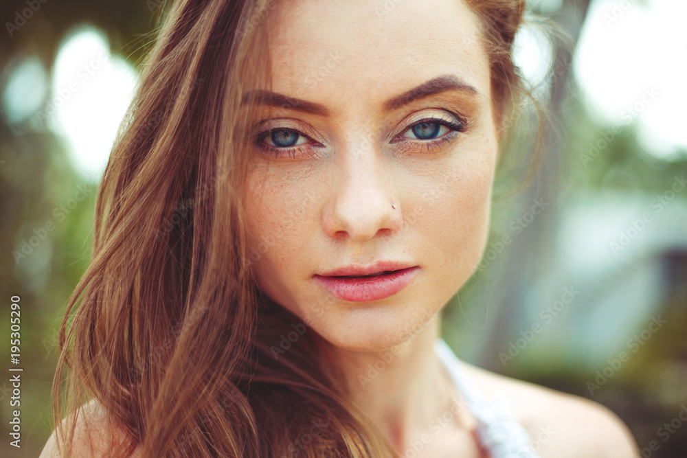 portrait of attractive young woman with long hair looking at camera portrait of attractive young woman with long hair looking at camera