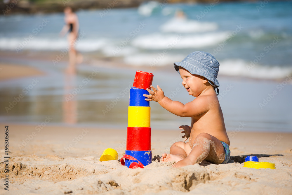 Kid plays with toys at the seashore in summertime Kid plays with toys at the seashore in summertime