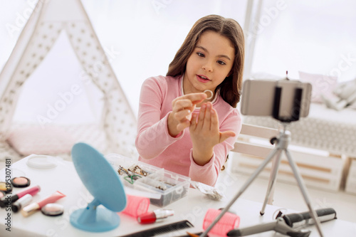 Nice purchase. Adorable pre-teen girl sitting at the table and showing a new ring to the camera while filming it for her new beauty blog entry