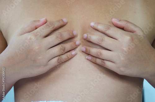 Health care medical concept. Close up of  young woman examining her breasts. photo