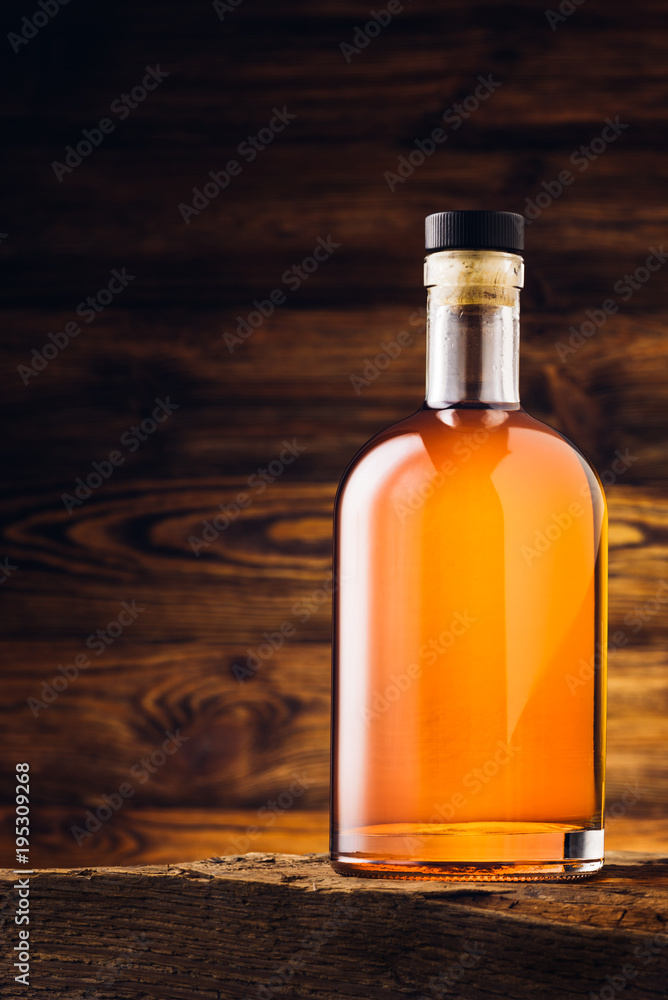 Whiskey bottle on the old wooden table Whiskey bottle on the old wooden table