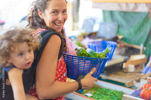 Two young women buying at the market of Antibes