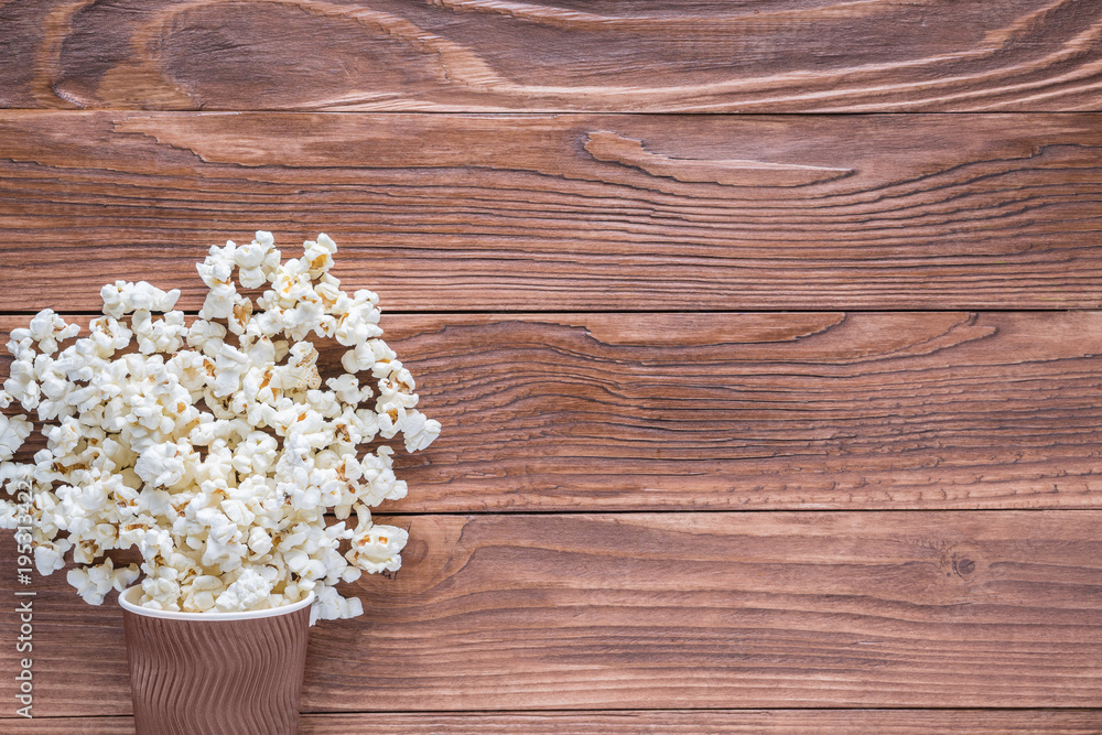 Popcorn in brown paper cups on rustic wooden background with copy space, top view, flat lay. Cinema concept. Popcorn in brown paper cups on rustic wooden background with copy space, top view, flat lay. Cinema concept.
