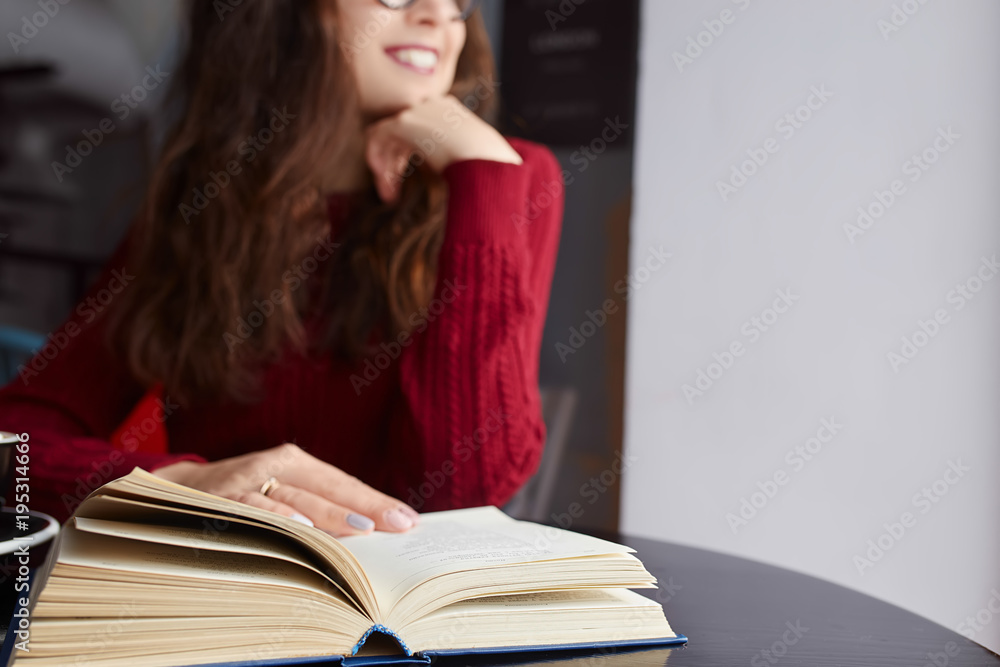 Young Beautiful Woman Reading Old Books, Using her Phone and Drinking Coffee or Cacao with Marshmallow. Relaxing atmosphere and Education. Young Beautiful Woman Reading Old Books, Using her Phone and Drinking Coffee or Cacao with Marshmallow. Relaxing atmosphere and Education.