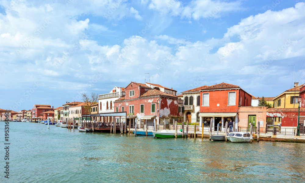 Daylight view to Venetian Lagoon canal with parked boats
