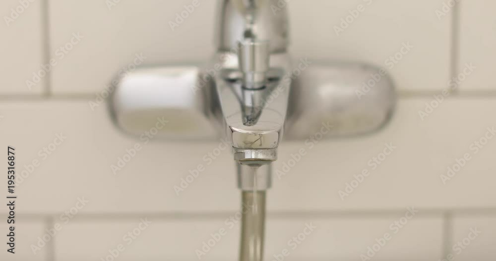 Metal tap and water drop close up in bathroom Metal tap and water drop close up in bathroom