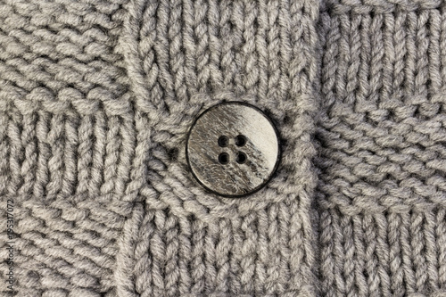 Button on gray knitted fabric