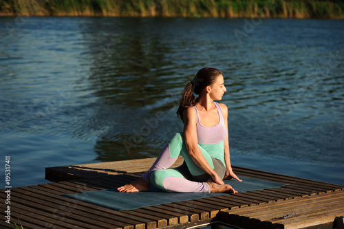 Close up of young woman doing yoga in the park with sunset © nagaets