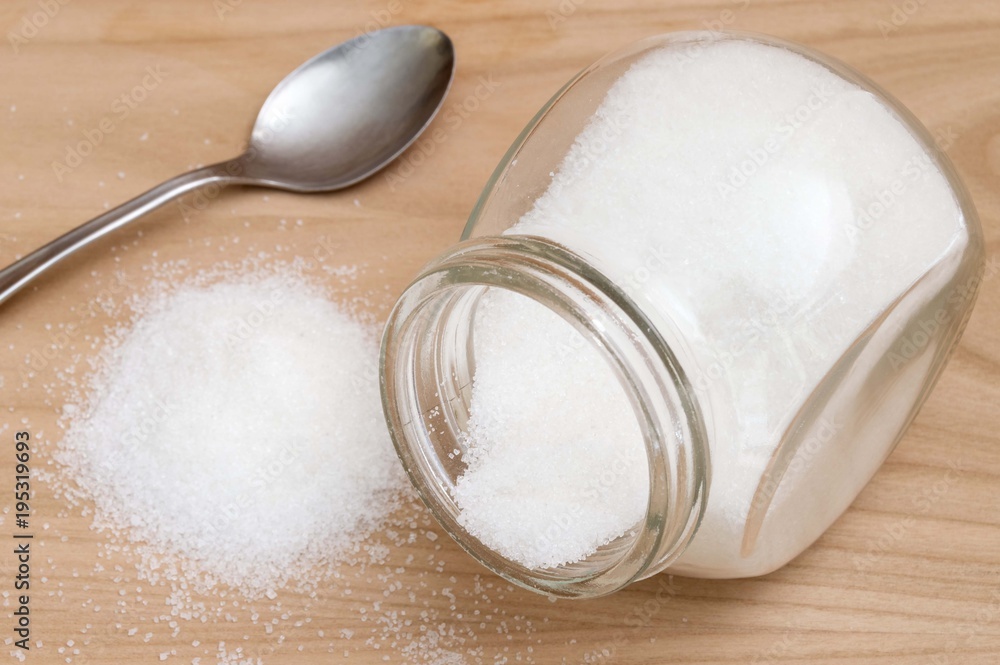 sugar inside a glass jar and spoon sugar inside a glass jar and spoon