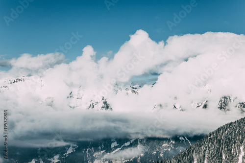 majestic snow-covered mountains and white clouds in mayrhofen, austria