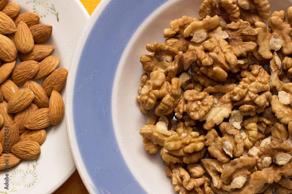 Almonds and walnuts in plates Almonds and walnuts in plates