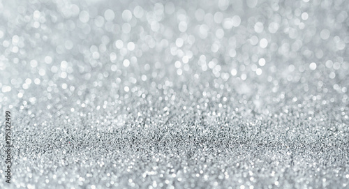 Sparkling festive background. Melting macro snowflakes close up with bokeh at the background. Image with small depth of field. Silver defocused glitter background with copy space.