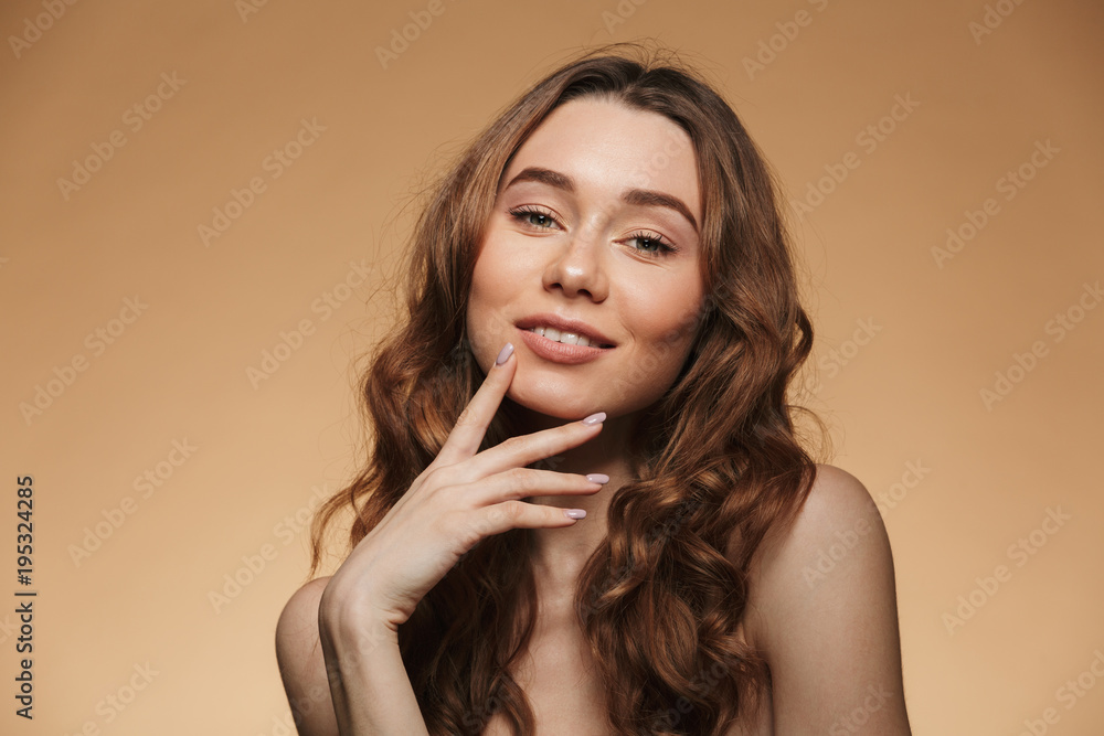 Beauty portrait of charming caucasian woman with brown hair looking at camera with lovely smile, isolated over beige background Beauty portrait of charming caucasian woman with brown hair looking at camera with lovely smile, isolated over beige background