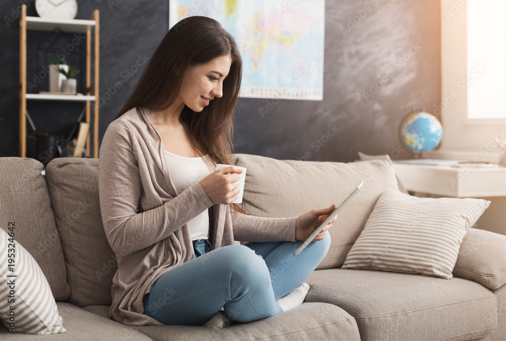 Girl reading on digital tablet and drinking coffee Girl reading on digital tablet and drinking coffee