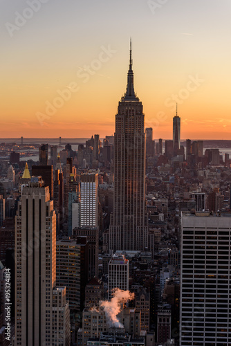 New York City - USA. View to Lower Manhattan downtown skyline with famous Empire State Building and One World Center and skyscrapers at sunset.