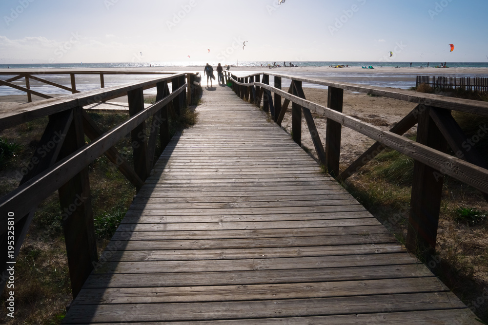 wooden bridge on beach with dark clouds before storm in Tarifa, Spain