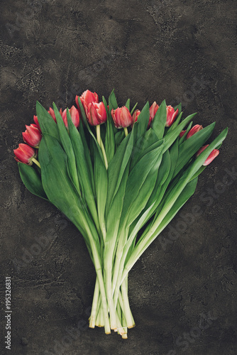 top view of beautiful red tulip flowers on dark surface