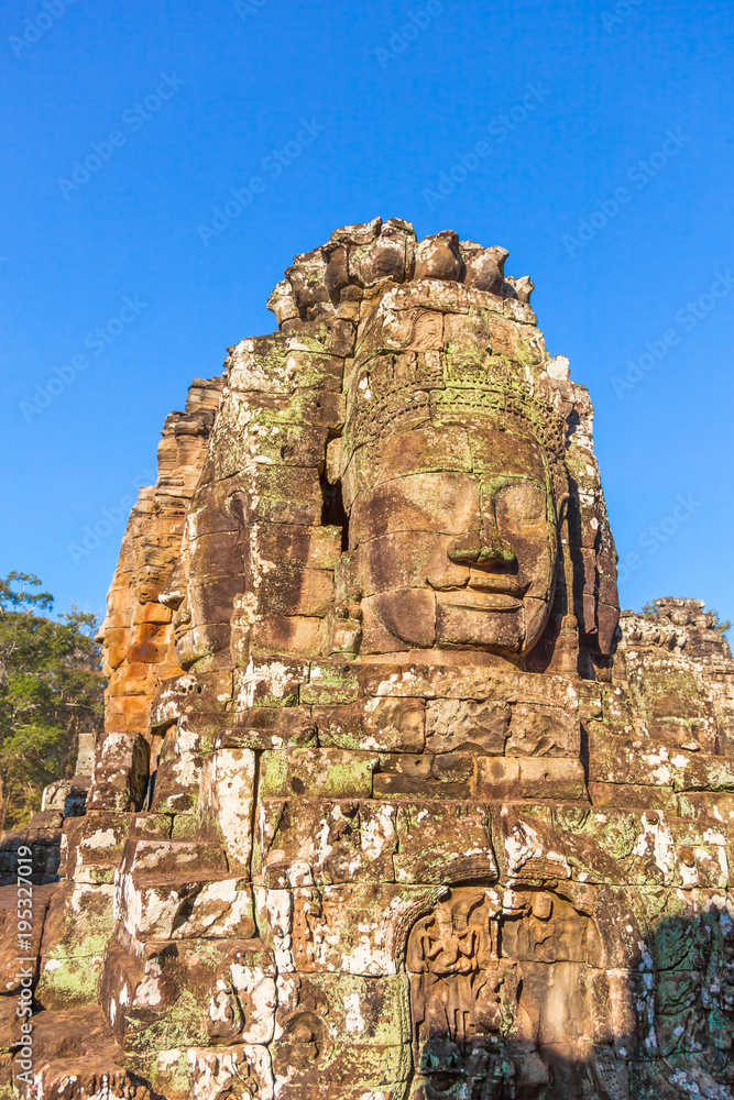 Face of Lokesvara, one of 200 at Bayon temple of Angkor Thom city of ancient Khmer empire. Tourist travel landmark of Angkor Wat complex in Cambodia near Siem Reap city.