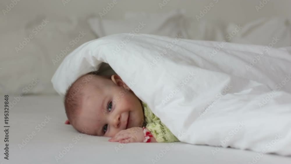 Portrait of a cute smiling infant baby boy in bed, smiling at camera Portrait of a cute smiling infant baby boy in bed, smiling at camera
