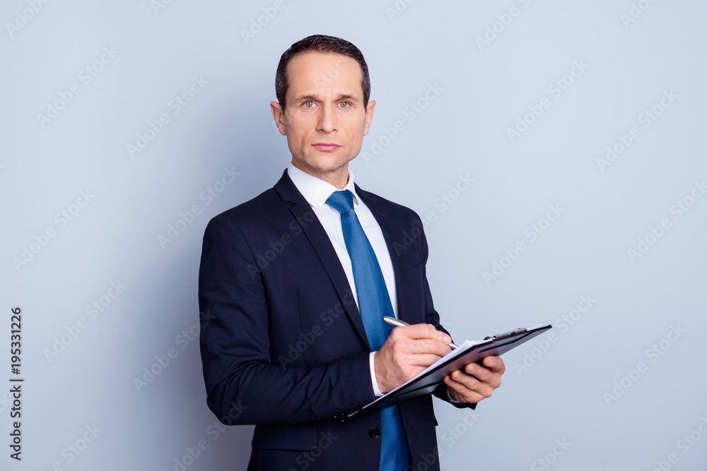 Portrait of focused clever intelligent concentrated representative with pencil and clipboard writing ideas checking work of staff manager in personnel department isolated on gray background copy-space Portrait of focused clever intelligent concentrated representative with pencil and clipboard writing ideas checking work of staff manager in personnel department isolated on gray background copy-space