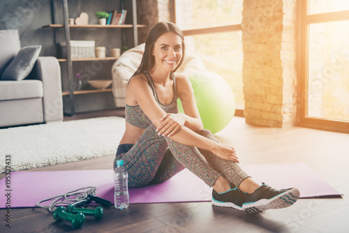 Wellbeing wellness endurance concept. Portrait of excited confident attractive active cheerful with toothy beaming smile skinny muscular woman sitting on purple mat near jump-rope looking at camera