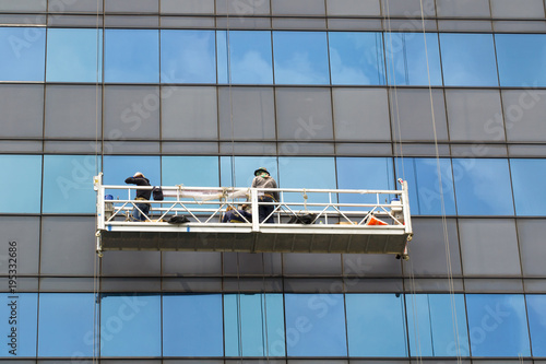 Male worker in overalls professional repair the windows in high-rise