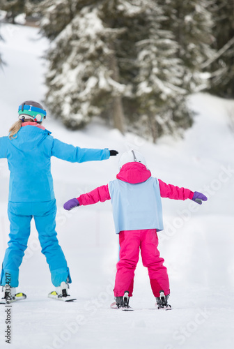 Child with teacher learning skiing