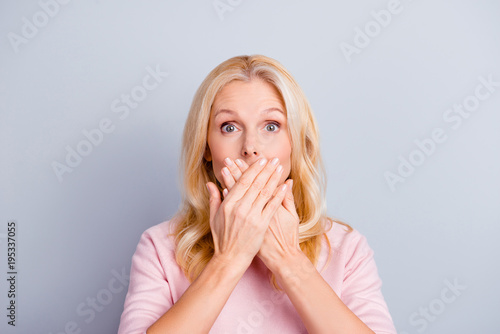 Close up portrait of funky curious cunning beautiful talkative gentle wondered astonished amazed lovely journalist grandmother grandma granny closes covers mouth isolated on gray background